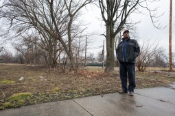 Steven Rogers stands in front of a vacant lot he owns on Normal Boulevard, between 56th Place and 57th Street on land slated for rail yard expansion by Norfolk Southern. Earlier this year, the railroad company sent him a letter of intent to enforce eminent domain. But Rogers refuses to give up his land and still has hopes to develop new residences for the Englewood community. "It should have never gotten to this," he says of the land battle with Norfolk Southern. (Photo by Max Herman)