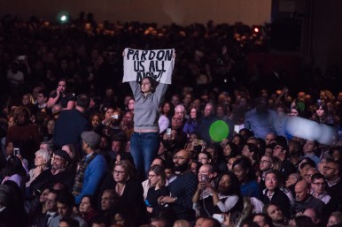 A protester with a sign reading, "Pardon us all now!" attempts to disrupt President Obama's farewell speech.