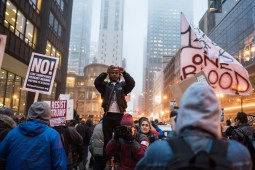 Activist and poet Malcolm London takes photos of people marching on Dearborn Street in protest of Donald's Trump inauguration on Jan. 20, 2017.