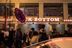 Bar goers in River North watch as demonstrators march in protest of Donald Trump’s inauguration on Jan. 20, 2017.