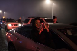 A woman reaches out of her car to photograph demonstrators marching on Lake Shore Drive in protest of the inauguration of Donald Trump on Jan. 20, 2017.