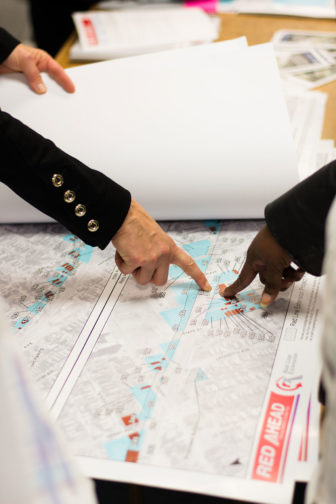 A CTA employee and resident point at a map highlighting properties marked as “displaced buildings” during a public hearing on the Red Line extension project held on Nov. 1, 2016 at St. John Missionary Baptist Church. 